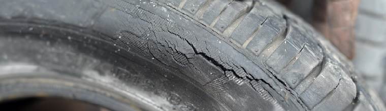 man holding a tyre with a crack on the sidewall