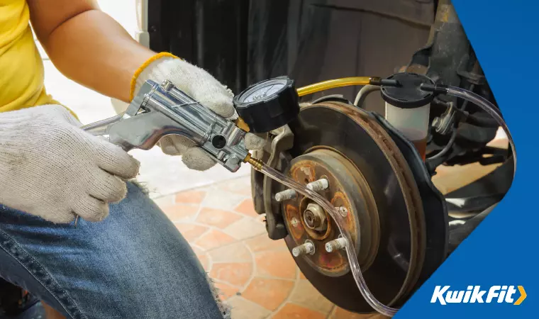 A technician uses a bleeding gun to bleed the brake lines properly.