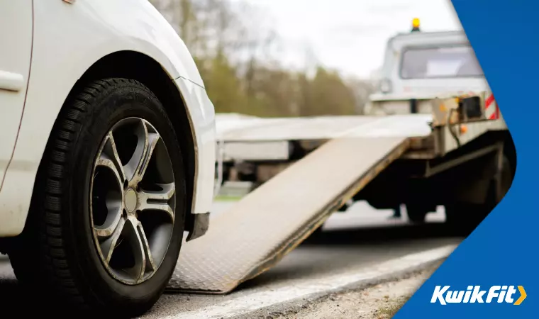 A broken down car is about to be towed from the side of the road.