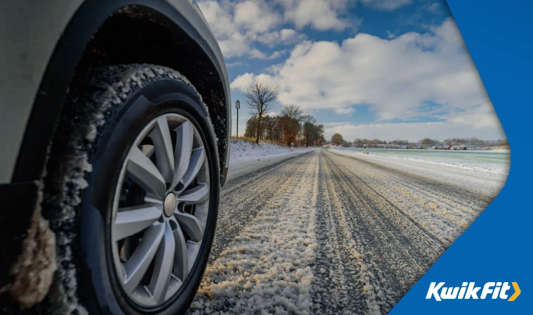 A car driving down a snowy road in winter.