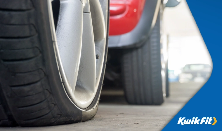 A deflated car tyre up close.