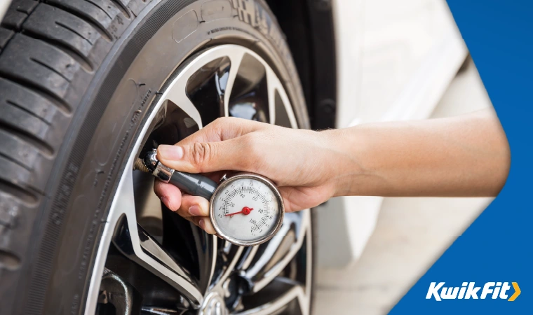 Someone checking the tyre pressure on their car.