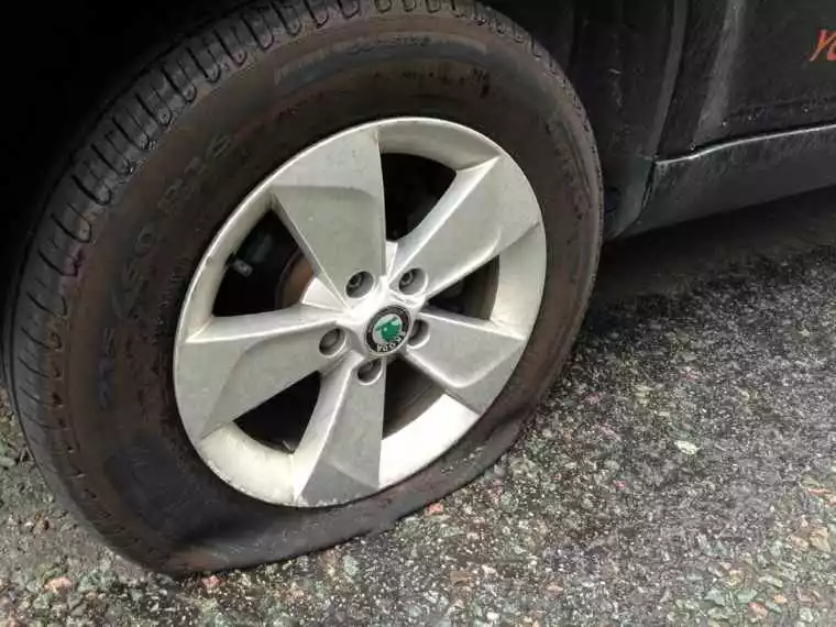 A completely deflated tyre lies flat against the tarmac.