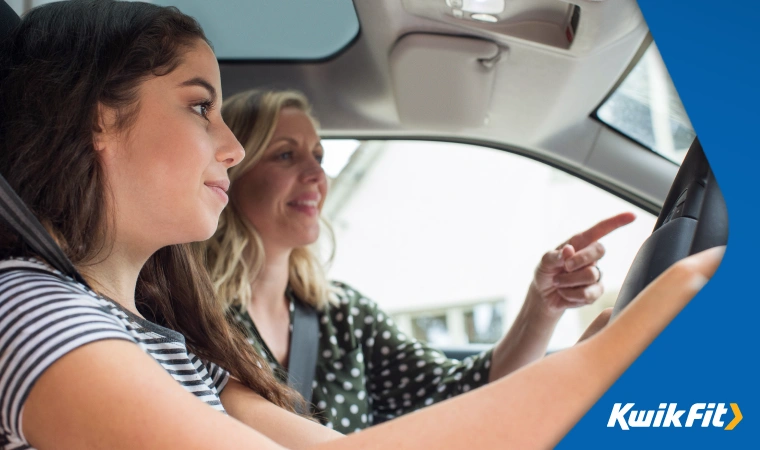 A driving instructor is pointing out potential hazards to a learner driver.