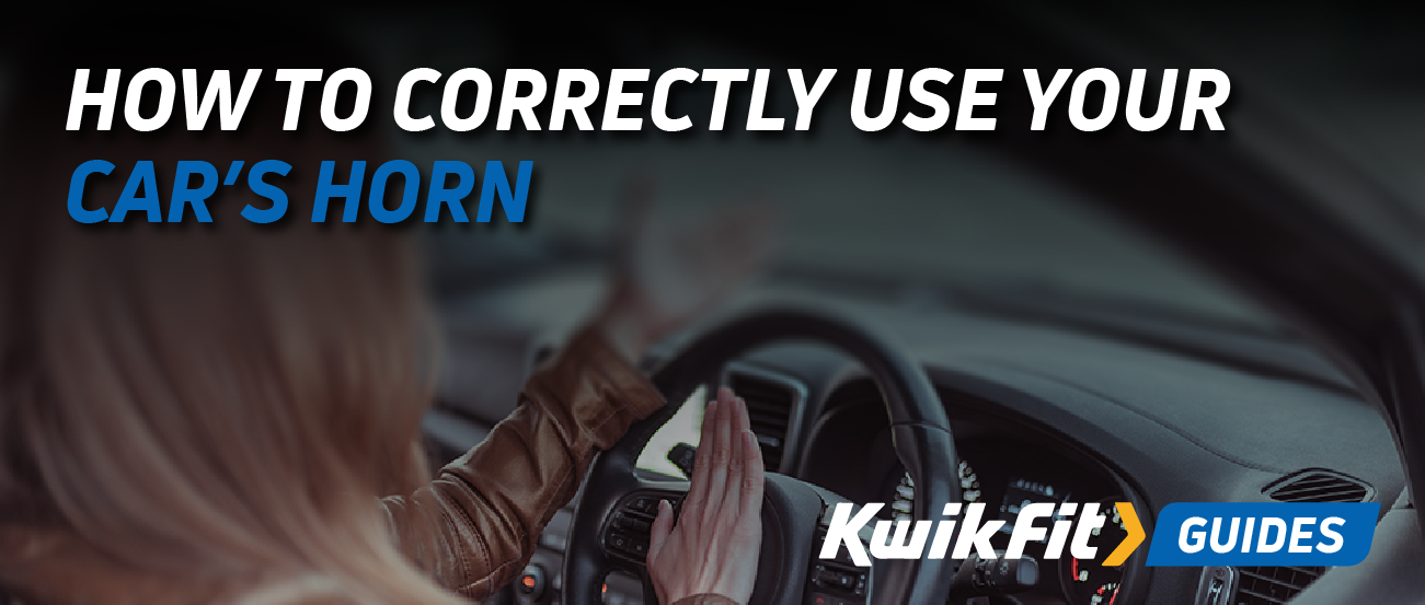 A woman in the car pressing her steering wheel to use the horn