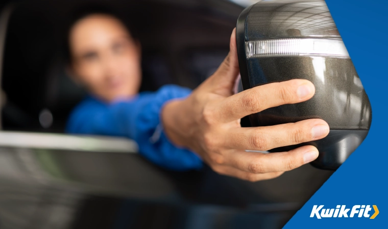 Person adjusting a wing mirror of a vehicle.