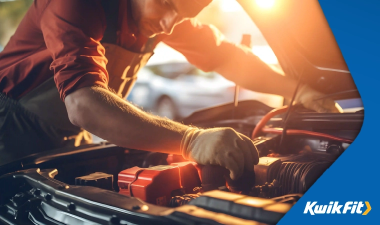 A mechanic changing a car battery.