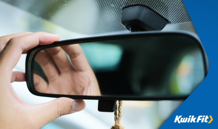 Driver adjusting their mirror before making a manoeuvre.