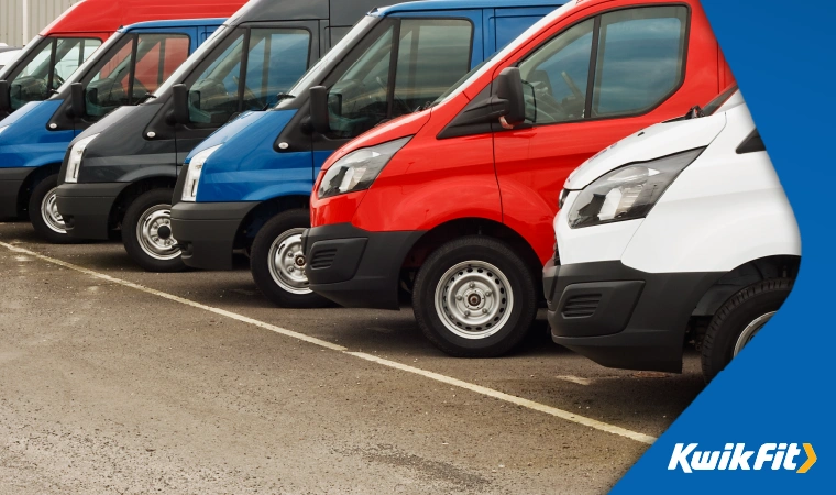 A number of vans of a variety of models are parked in a line.