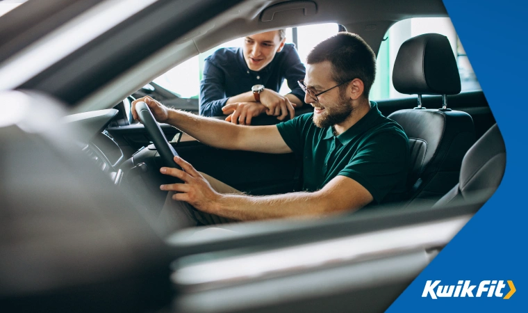 Man sits in car driver's seat, getting a feel for the car and planning a test drive.