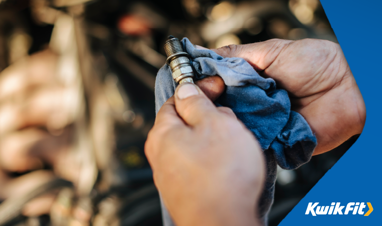 Person cleaning a knock sensor with a blue cloth.