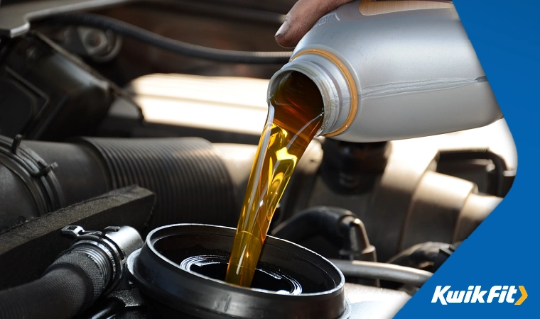 Engine oil being poured into a cars oil reservoir.